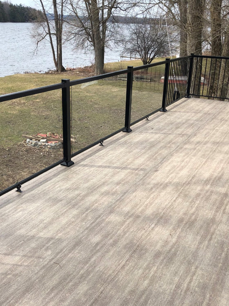Three construction workers applying bright light blue waterproof coating on outdoor balcony